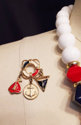 *VINTAGE 1980s NAUTICAL METAL ANCHOR NECKLACE AND EARRINGS WITH FLAG, ANCHOR AND SAILBOAT DANGLING FROM A LIFE PRESER